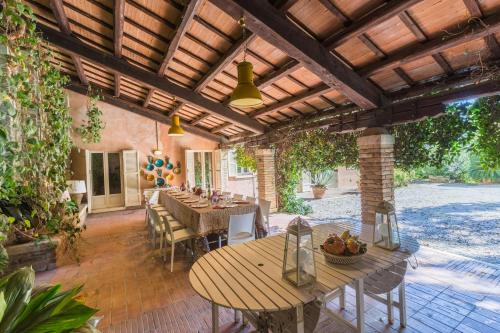 a patio with tables and chairs under a wooden pergola at Villa Anna Maria in Centobuchi