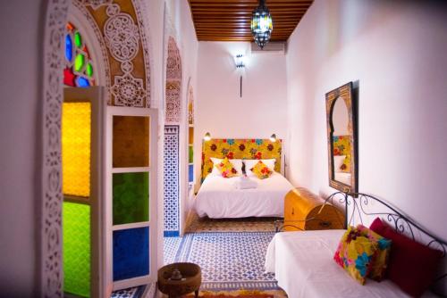 a bedroom with a bed and a mirror in a room at Riad Safir in Meknès