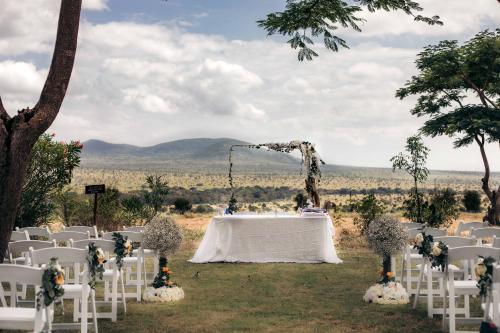 a table and chairs in a field with a wedding at Taita Hills Safari Resort & Spa in Tsavo