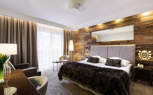 a bedroom with a large bed and a large mirror at Sandra Spa Karpacz & Aquapark in Karpacz