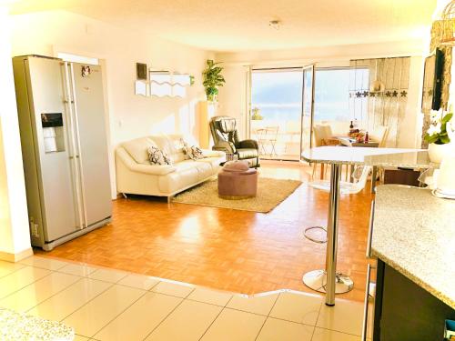eine Küche und ein Wohnzimmer mit einem Kühlschrank in der Unterkunft Spacious Apartment with Lake View | 35 in Montreux