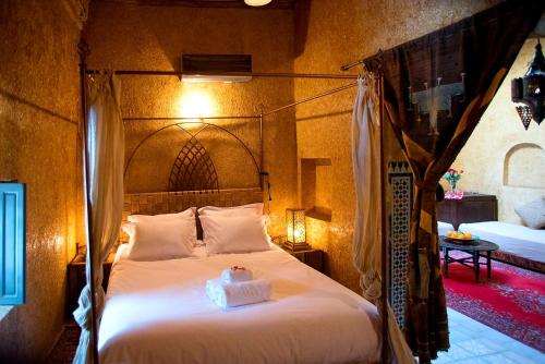 a bedroom with a large bed with a wooden headboard at Riad Safir in Meknès