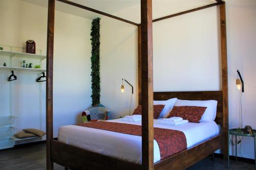 a bedroom with a four poster bed with white sheets at Terre di Sicilia in Marsala