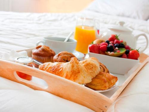 a breakfast tray with pastries and fruit on a bed at Room with A View in London