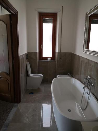 a bathroom with a tub and a toilet and a sink at Babbo maison in Guidonia