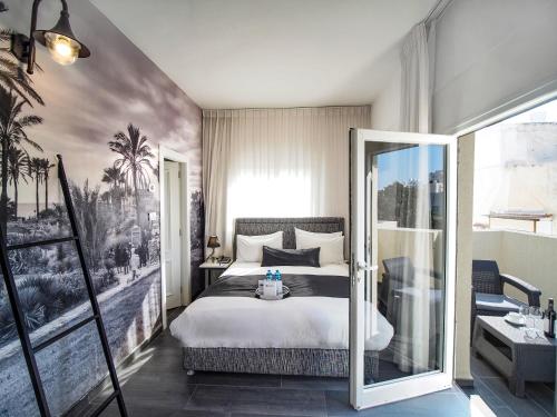 Pokój hotelowy z łóżkiem i lustrem w obiekcie Dizengoff Avenue Boutique Hotel w Tel Awiwie