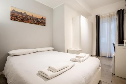 una camera da letto con un letto bianco e asciugamani di My place a Roma