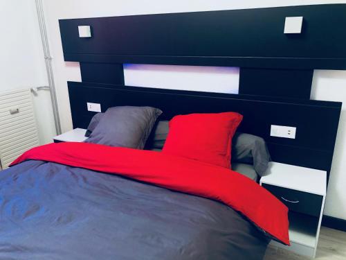 Una cama con una manta roja encima. en Bella vita en Thonon-les-Bains