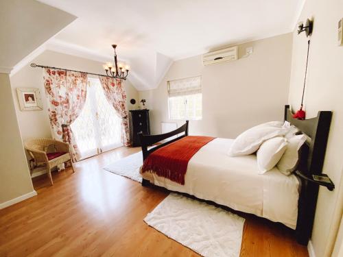 Jonquil Guest Cottage في فرانستشوك: غرفة نوم بسرير كبير مع بطانية حمراء