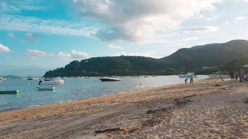 una spiaggia con barche in acqua e in montagna di Recanto do Mica a Governador Celso Ramos