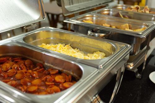a bunch of trays of food in a kitchen at Abudi Hotel in Cuiabá