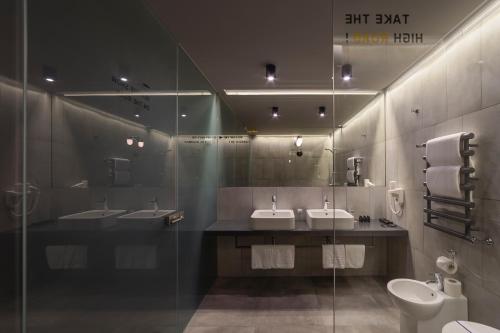 a bathroom with two sinks and two mirrors and a toilet at Дизайн-готель ROAD in Kyiv