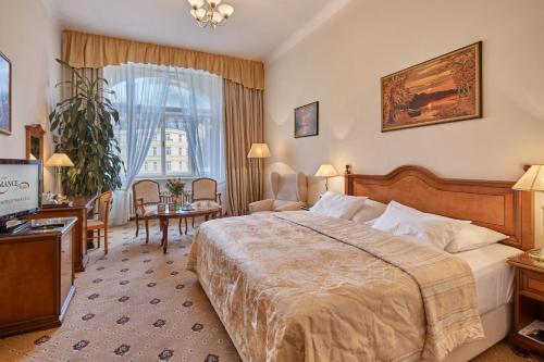 um quarto de hotel com uma cama e uma televisão em Hotel Romance em Karlovy Vary