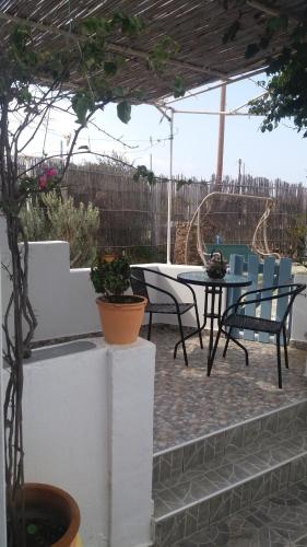 a patio area with a patio table and chairs at Korina's Rooms in Pollonia