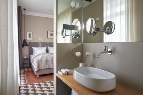 a bathroom with a sink and a bedroom with a bed at Bagatelle Gardenhouse in Budapest