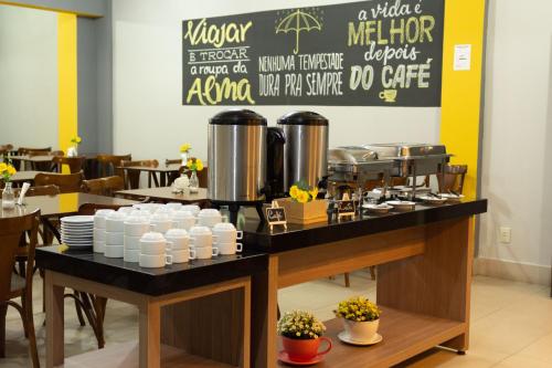 a restaurant with a counter with dishes on it at Abudi Hotel in Cuiabá
