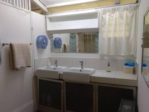 uma casa de banho com 2 lavatórios e um espelho em Moonriver Lodge em Cameron Highlands