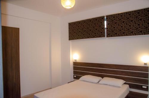 a bedroom with a bed with two white pillows at VELVET RESIDENCE in Mamaia Sat/Năvodari