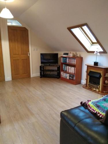 a living room with a couch and a tv and a skylight at Ivydene Cottage in Mablethorpe