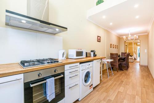 a kitchen with a stove and a washer and dryer at Belem Skinny House in Lisbon