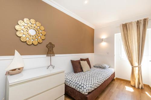 1 dormitorio con cama y espejo en la pared en Belem Skinny House, en Lisboa