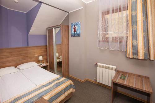 利維夫的住宿－Lviv Central Jam Hotel，酒店客房配有一张床铺和一张桌子。