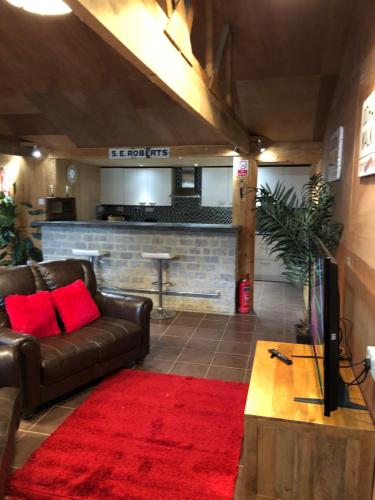 a living room with a leather couch and a red rug at The Lodge in Bedford