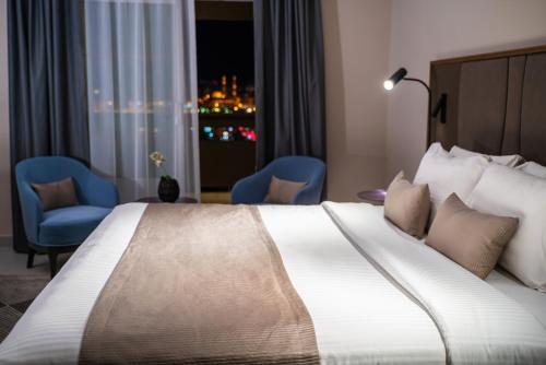 a hotel room with a large bed and a window at Hotel Holiday International in Sharjah