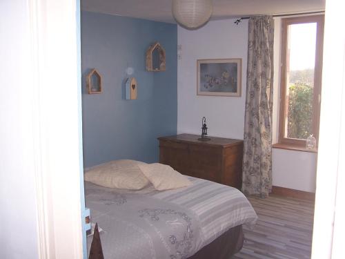 a bedroom with a bed and a dresser and a window at Gite en Forterre in Druyes-les-Belles-Fontaines