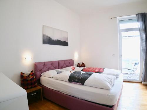a bed with a pink headboard in a bedroom at Suite Mutters in Innsbruck