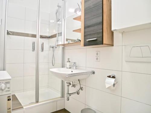 a white bathroom with a sink and a shower at Suite Mutters in Innsbruck