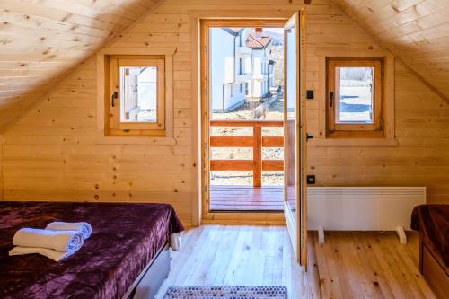 ein Schlafzimmer mit einem Bett und einem großen Fenster in der Unterkunft Happy2cu Cabin in Kolašin