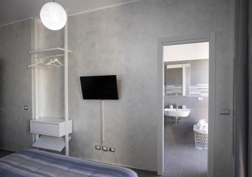 um quarto com uma cama, uma televisão e um lavatório em Smart Central Apartments em Milão