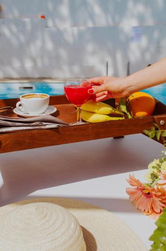 a person holding a drink on a tray with a table at Residence Le Terrazze in Sorrento