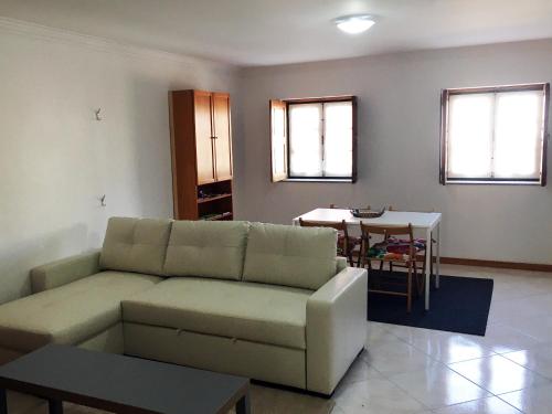 ein Wohnzimmer mit einem Sofa und einem Tisch in der Unterkunft Casa da Gramática in Viana do Castelo