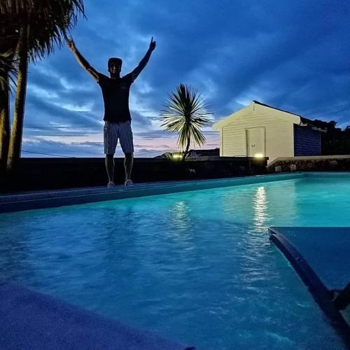 a man standing on the edge of a swimming pool at GRANARY'S HOUSE in Sete Cidades