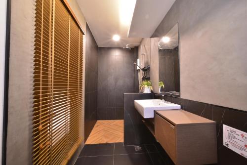 a bathroom with a white sink and a mirror at Sureena Hotel in Pattaya Central