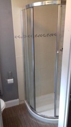 a shower with a glass door in a bathroom at Lansdown House Bed & Breakfast in Market Drayton