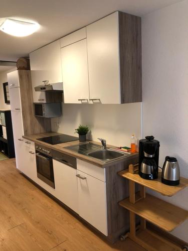レンゲンフェルトにあるApartment Felixの白いキャビネットとシンク付きのキッチン