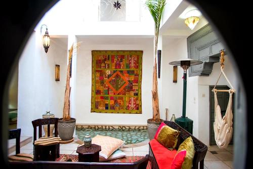 a living room filled with furniture and a painting on the wall at Riad Safir in Meknès