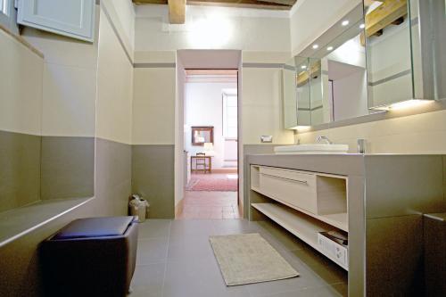 uma casa de banho com um lavatório e um banco em The Piano Nobile em Montepulciano