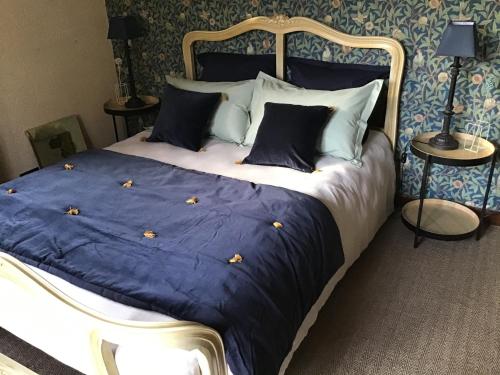 Elle comprend un grand lit avec des draps et des oreillers bleus et blancs. dans l'établissement la VILLA B Chantilly, à Orry-la-Ville