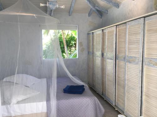 une chambre avec un lit et une fenêtre dans l'établissement Villa Iguanou et piscine en bord de mer proche plages marina et golf, à Saint-François