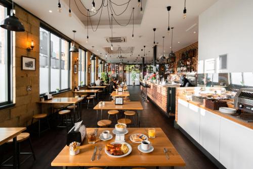 a restaurant with wooden tables and a bar at London City Airport Hotel in London