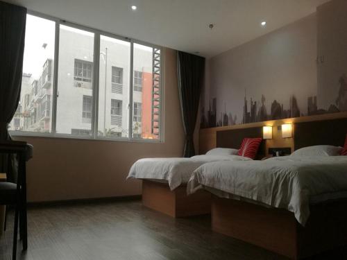 a bedroom with two beds and a large window at Thank Inn Chain Hotel guangxi liuzhou wal-mart jinfudi in Liuzhou