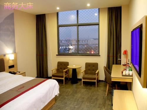 a hotel room with a bed and a desk and a window at Thank Inn Chain Hotel shanxi xianyang sanyuan county yuyuan road in Xianyang