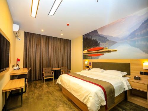 a hotel room with a large bed and a desk at Thank Inn Chain Hotel Jiangsu Yancheng dongtai Jianggang town in Cuiguangshan