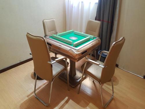 una mesa de ping pong con 4 sillas alrededor en Thank Inn Chain Hotel Shanxi xianyang train station, en Xianyang