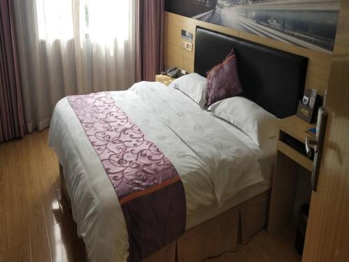 - un grand lit dans une chambre d'hôtel avec publicité dans l'établissement Thank Inn Chain Hotel guizhou south prefecture longli county high-speed railway station, à Longli