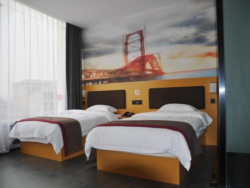2 camas en una habitación con una pintura de un estadio en Thank Inn Chain Hotel Shandong linyi hedong hot spring resort, en Linyi